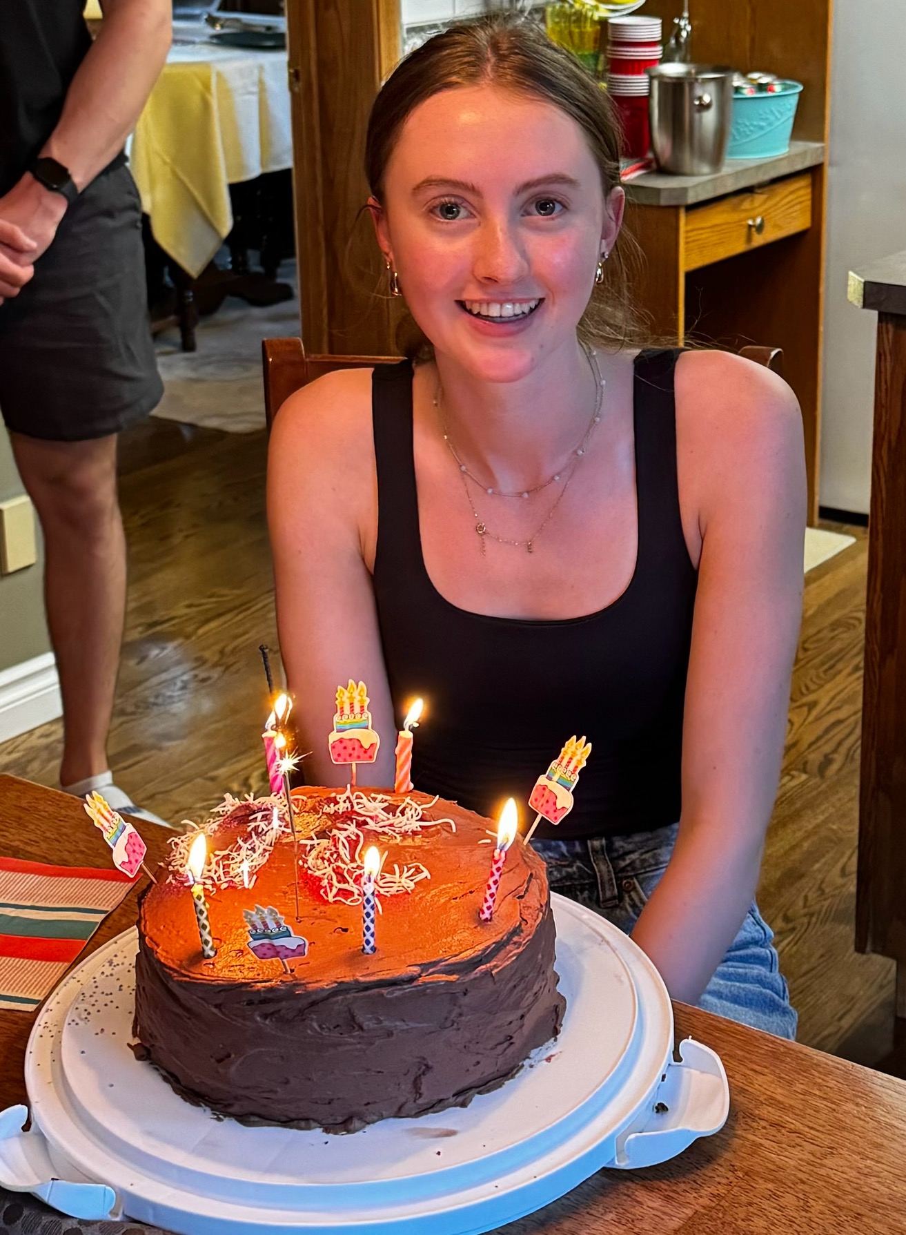 Elle smiling behind a birthday cake with lit candles