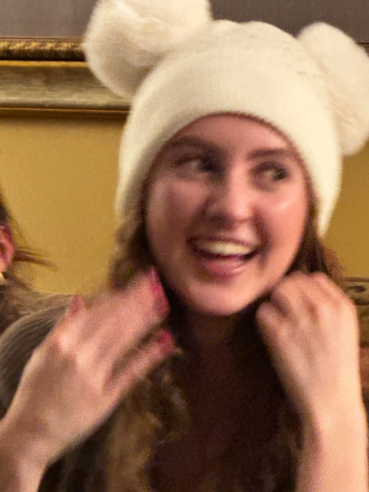 Elle laughing in a fluffy white hat