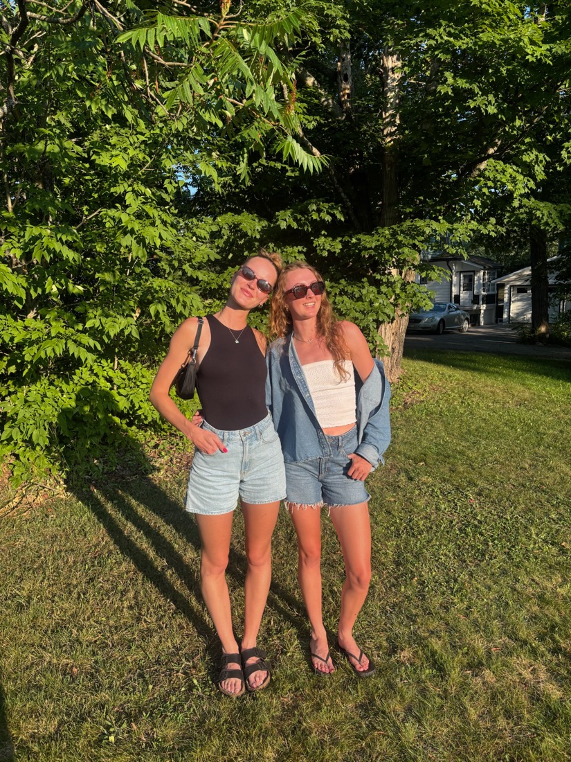 A sunny family photo of two women standing together outdoors